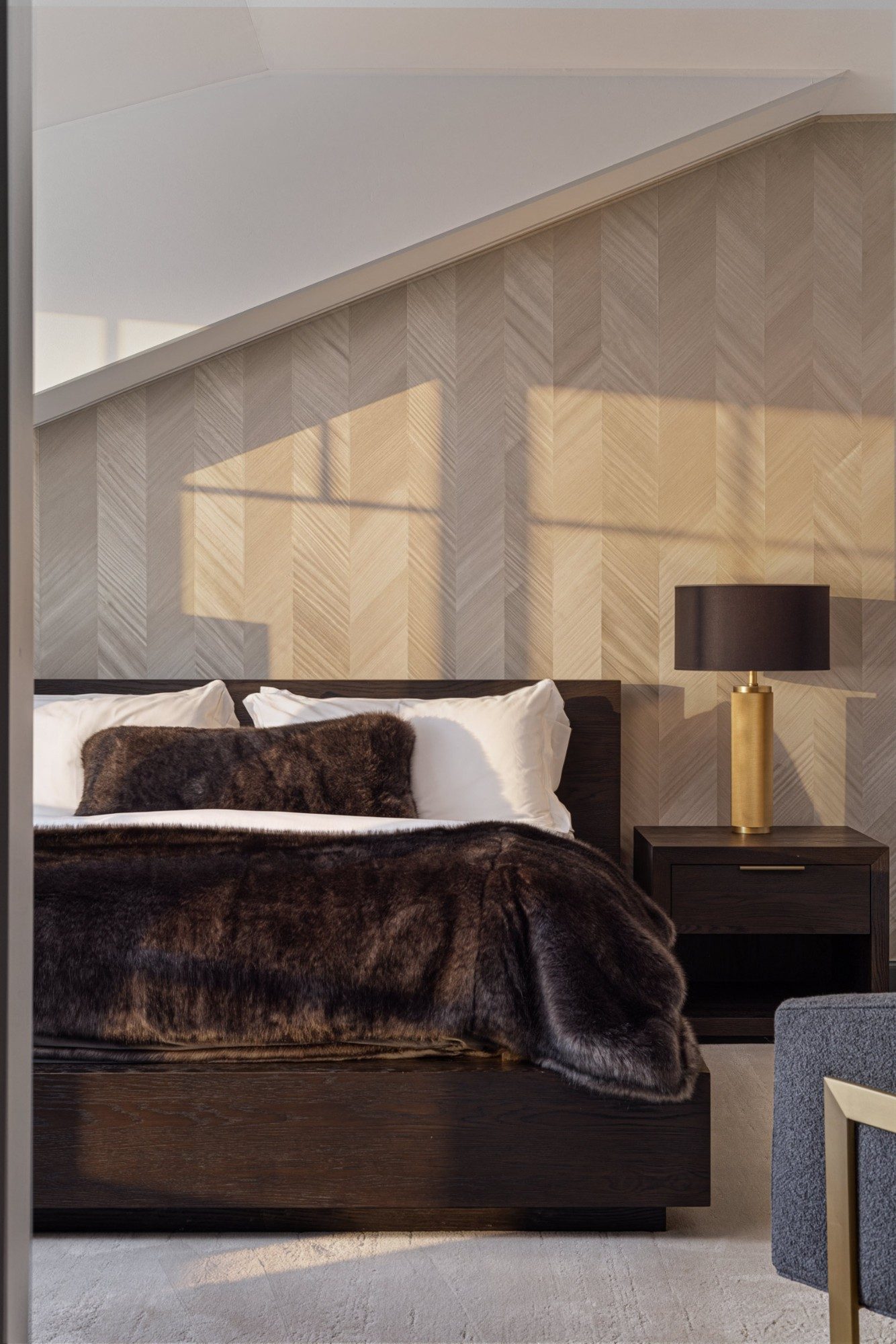 Bedroom with a chevron-paneled wall, black bed and brass reading lamp, Telluride interior photography