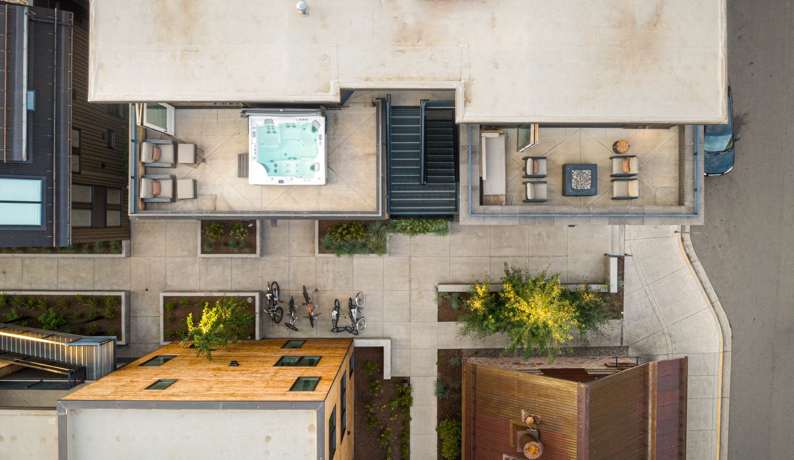 Top-down aerial drone view of a modern mountain residence with rooftop hot tub and courtyard, FAA-certified drone photography